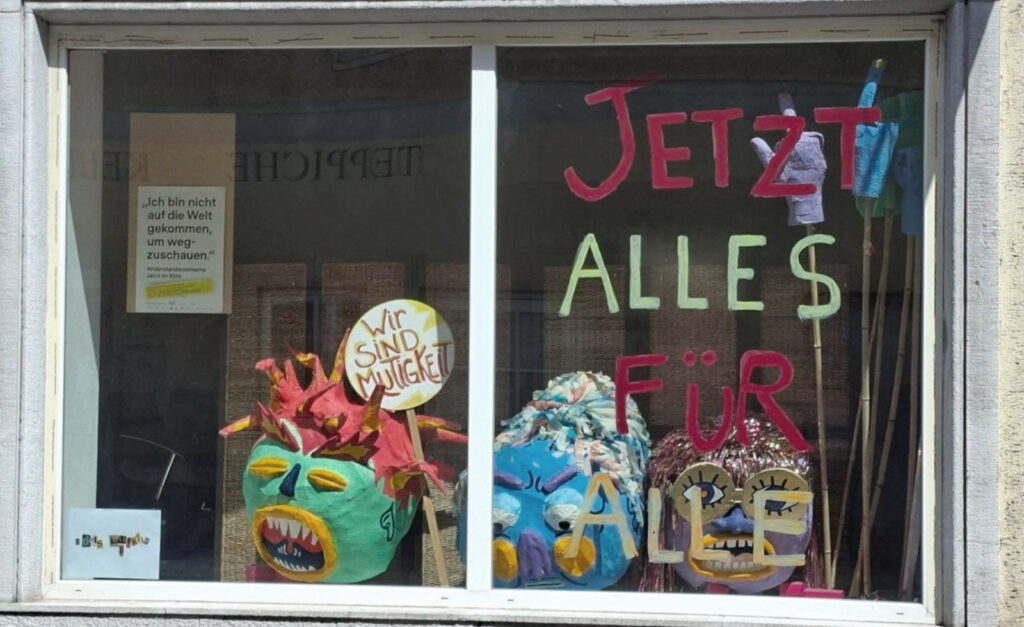 Schrift in einem Fenster "Jetzt alles für alle"
